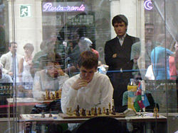 Teimour Radjabov kijkt van een afstand naar zijn rivaal Magnus Carlsen.
