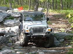 Jeep Wrangler navegando em um obstáculo rochoso