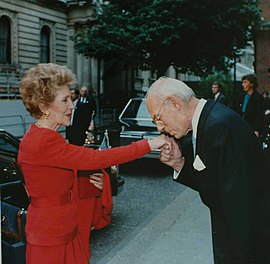 Denis Thatcher, mari de Margaret Thatcher, embrassant la main de Nancy Reagan, épouse du président américain en 1988