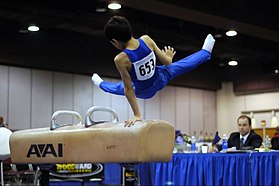 En gymnast på en tävling i pommelhästen.  