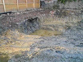 Exemple de friche industrielle sur un site d'usine à gaz désaffecté après excavation, avec contamination du sol par des réservoirs de stockage souterrains enlevés.
