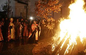 Een Servisch-orthodoxe priester legt de badnjak op een vuur tijdens een kerstavondviering in de tempel van de heilige Sava in Belgrado.  