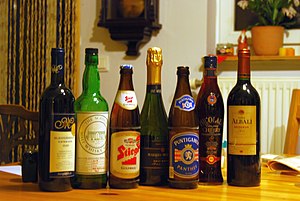 Wat alcoholische dranken. Van links naar rechts: rode wijn, malt whisky, pils, mousserende wijn, pils, kersenlikeur en rode wijn.