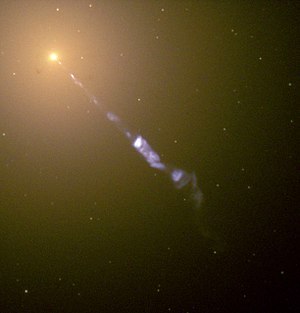 Hubble-ruimtetelescoopbeeld van een 5000 lichtjaren lange (1,5-kiloparsec-lange) straal die uit de actieve kern van het actieve melkwegstelsel M87, een radiogalkwegstelsel, wordt geworpen. De blauwe synchrotronstraling van de straal contrasteert met het gele sterlicht van het gastmelkwegstelsel.