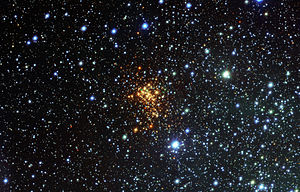 Westerlund 1: de hete OB-superreuzen stralen meestal blauw licht uit - ze verschijnen echter als rode sterren in het zichtbare lichtbeeld. Dit komt omdat het blauwe licht van de sterren is geabsorbeerd door gas, waardoor het rood wordt.