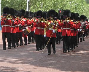 Britannian armeijan Welsh Guardsin soittokunta soittaa, kun vartijat marssivat Mallin varrella Buckinghamin palatsin vartiovuoron vaihtamiseksi