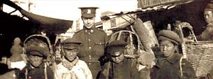 En kanadensisk soldat poserar med pojkar i Vladivostok.  