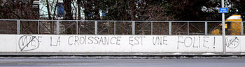 Lozan'da DEF karşıtı grafitiler. Yazıda şu ifadeler yer alıyor: La croissance est une folie ("Büyüme deliliktir").