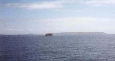 Ortac i fjärran, sett från färjan. Alderney ligger i bakgrunden.  