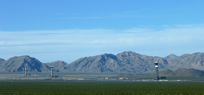 Vedere a sistemului de generare a energiei electrice solare Ivanpah de pe Yates Well Road, comitatul San Bernardino, California. În depărtare se poate vedea lanțul muntos Clark.  