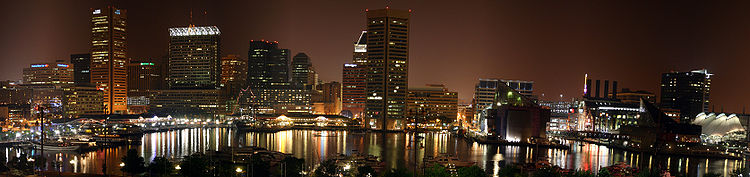 Een nachtelijk panorama van Baltimore's Inner Harbor.  