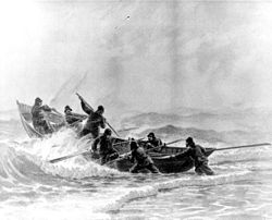 Une équipe de sauvetage met à l'eau un bateau de surf à travers les vagues. Avec l'aimable autorisation du bureau de l'historien des garde-côtes américains.