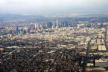 Aerial view over Los Angeles. In the foreground are residential areas, adjacent to industrial and business districts. Glendale and part of the Santa Monica Mountains can be seen in the background. Downtown is in the center.