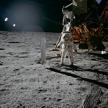 Astronavt Buzz Aldrin stoji ob eksperimentu o sestavi sončnega vetra.