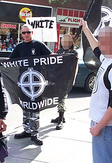 Banier omhoog gehouden door een persoon tijdens een "White Pride" bijeenkomst in Calgary, Canada.  