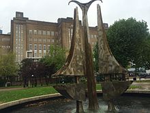 El edificio principal con la escultura acuática Tipping Triangles de Angela Conner. El edificio es uno de los mayores edificios independientes de ladrillo de Europa.  