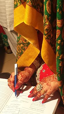Una novia firmando el certificado de matrimonio, en Pakistán.