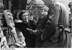 Dit is een veel complexere vorm van interactie. Duitse soldaten praten met een Franse vrouw in Lotharingen, Frankrijk, november 1940.