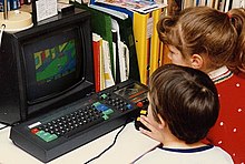 Children play the video game Paperboy on an Amstrad CPC 464 home computer in the 1980s.