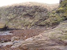 Falha geológica em Niarbyl, Ilha de Man. A estreita linha diagonal branca perto do centro da imagem é o único sinal visível que resta do Oceano de Iapetus.