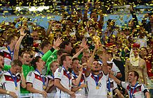 Podolski (with the trophy) after winning the 2014 World Cup.