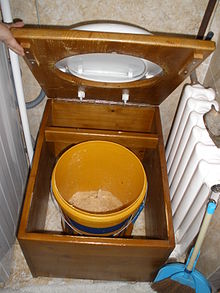 Um banheiro com balde, que também é um tipo de vaso sanitário baseado em contêineres.