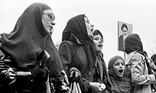 Жени, протестиращи по време на Ислямската революция в Иран, с високо вдигната снимка на Хомейни  