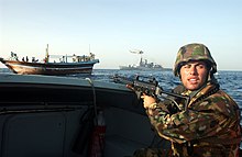 Een Italiaanse marinier stelt de veiligheid in voor zijn team om veilig aan boord van een lading te gaan om het schip te doorzoeken  