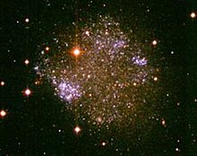 Die irreguläre Galaxie Sextans A gehört zur Lokalen Gruppe von Galaxien und ist 4,3 Millionen Lichtjahre weit entfernt. Die hellen Milchstraßen-Vordergrundsterne erscheinen in dieser Ansicht gelblich. Dahinter liegen die Sterne von Sextans A mit jungen blauen Sternhaufen deutlich sichtbar.