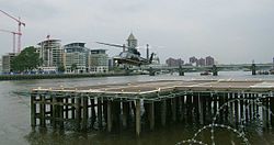 Uma aterrissagem Sikorsky S-76A no cais do heliporto de Londres no rio Tamisa. Battersea Railway Bridgeis no fundo