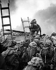 Yhdysvaltain merijalkaväen sotilas kiipeämässä Inchonissa 15. syyskuuta 1950 Korean sodan aikana.  