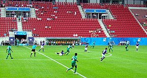 The referee (in turquoise) indicates advantage after a foul on a Japanese player (in blue) as Japan continues to possess the ball