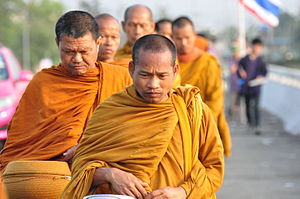 Monaci buddisti thailandesi che camminano la mattina presto per raccogliere l'elemosina.
