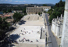 The square of the Papal Palace with the Petit Palais in the background of the square; behind it the plain of the Rhone and the Pont Saint-Bénézet; behind it the Fort Saint-André of Villeneuve-lès-Avignon