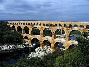 Den romerske akvædukt Pont du Gard, Frankrig. Det øverste niveau omslutter en akvædukt, der i romersk tid førte vand til Nimes; det nederste niveau blev udvidet i 1740'erne for at føre en bred vej over floden.  