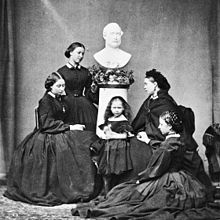 De vijf dochters van Victoria (Alice, Helena, Beatrice, Victoria en Louise) fotografeerden in rouwzwart onder een borstbeeld van hun overleden vader, prins Albert (1862).