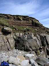 Suelo con fragmentos de rocas rotas sobre el lecho de roca, Sandside Bay, Caithness.