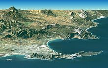 Península del Cabo y Montaña de la Mesa-Imagen Landsat. Ciudad del Cabo y el Cabo de Buena Esperanza (Sudáfrica) aparecen en primer plano. El centro de la ciudad está en la Bahía de la Mesa (abajo a la izquierda), junto a la Montaña de la Mesa. La gran bahía que mira hacia la derecha (Sur) es la bahía de False.
