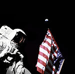 Harrison Schmitt, astronautul de pe Apollo 17, pe Lună, cu Pământul vizibil pe cer.  