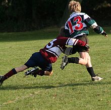 En rugbytackling: tacklingar måste ske lågt ner på kroppen, i syfte att hindra eller sätta spelaren med bollen på marken.  