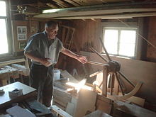 Master wheelwright building a wagon wheel