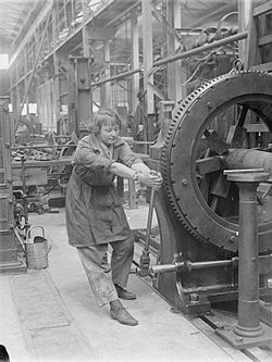 Een werkneemster bedient een geweermachine in een Royal Gun Factory, 1918