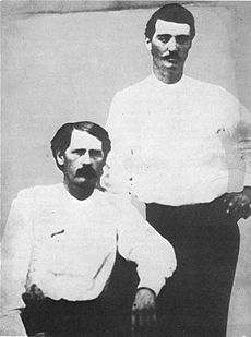 Abipolitseinikud Bat Masterson (vasakul) ja Wyatt Earp Dodge Citys 1876. aastal. Earpi rinnal olev rull on riidest rinnamärk.